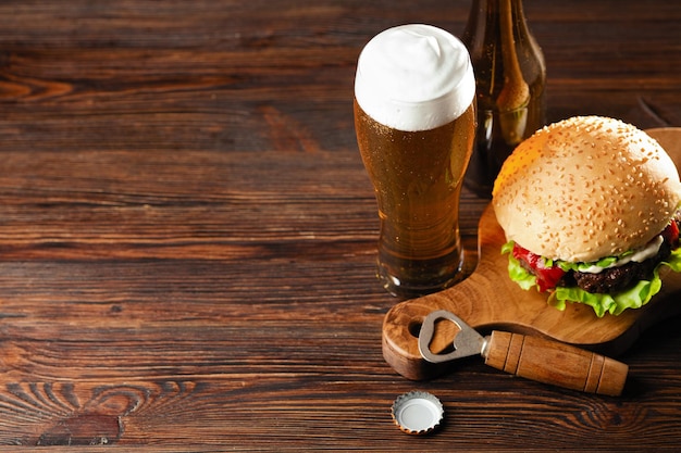 Conjunto de cerveza de hamburguesa y papas fritas Un conjunto estándar de bebidas y comida en el pub Cerveza y bocadillos Comida rápida de fondo oscuro Comida americana tradicional