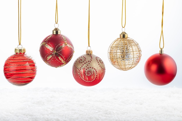 Conjunto de cinco hermosas bolas rojas y doradas de Navidad en blanco nevado