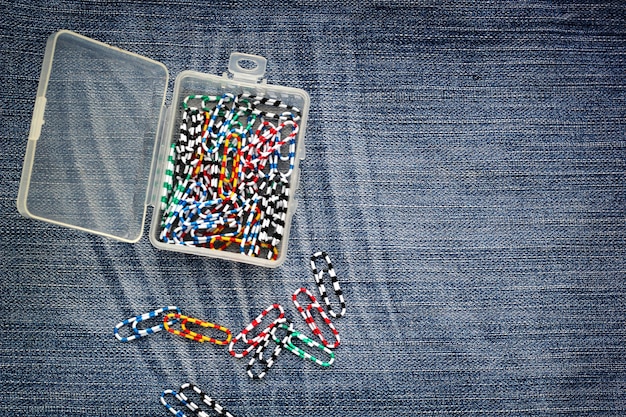 Conjunto de clips de colores en caja de plástico en jeans