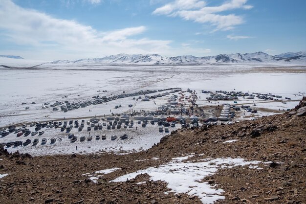 Foto conjunto de coches y yurts de turistas en una pendiente cubierta de nieve soleada