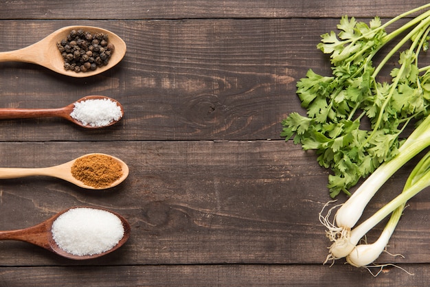 Conjunto de colección de especias en cucharas de madera y verduras.