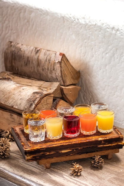 Conjunto colorido de coquetéis alcoólicos em atiradores de copos de shot na mesa de madeira para uma festa alcoólica.