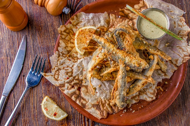 Conjunto com frutos do mar, pequeno peixe do mar frito, comida que geralmente é servida com cerveja, orientação horizontal e vista superior