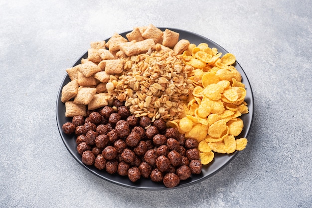 Conjunto de copos de cereales secos para el desayuno con leche y bayas.