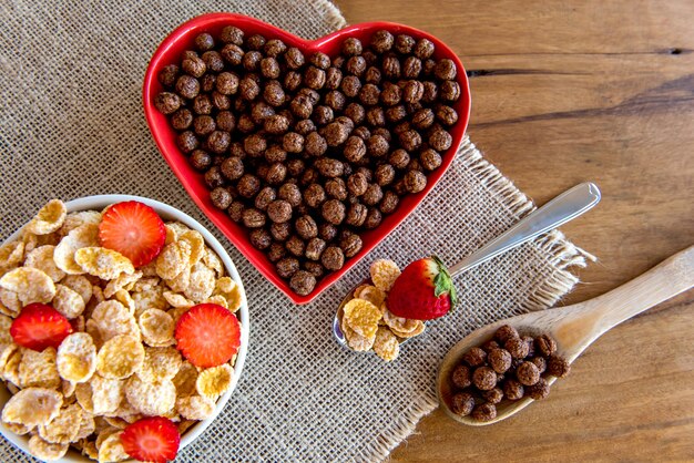 Conjunto de copos de maíz. Cereales para el desayuno. Copos de maíz con fresa.