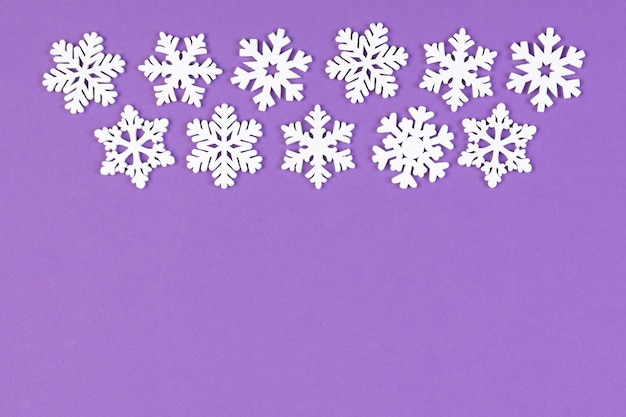 Conjunto de copos de nieve blancos sobre fondo de colores. Vista superior del adorno de Navidad. Concepto de tiempo de año nuevo con espacio vacío para su diseño.