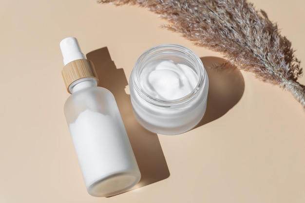 Foto conjunto de cosméticos naturales para el tratamiento facial productos orgánicos en botellas de vidrio - crema esencia