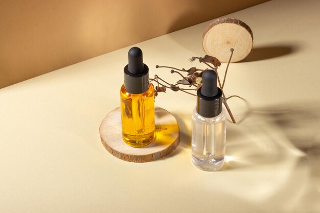 Un conjunto de cosméticos para la sauna y el spa Recipiente de vidrio transparente con aceite natural para el cuerpo y el cabello en un soporte de madera Diseño de estilo Diseño Cosmetología y concepto de belleza