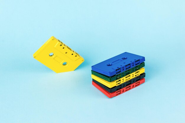 Un conjunto creativo de casetes de cinta multicolores sobre un fondo azul Estilo vintage en la grabación de sonido Concepto de audio mínimo laico plano