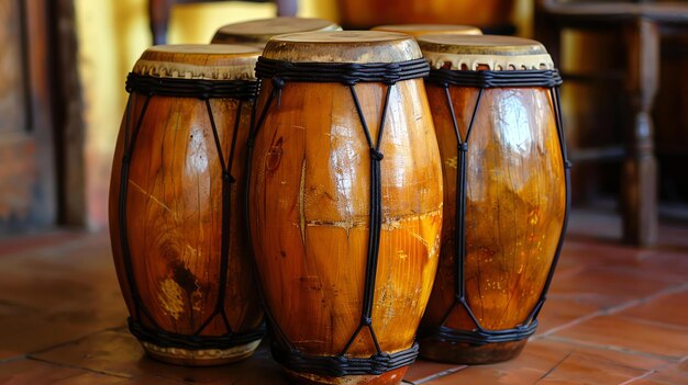 Foto un conjunto de cuatro bongos de madera los bongos están hechos de madera y tienen cuerdas negras envueltas a su alrededor se sientan en una superficie marrón