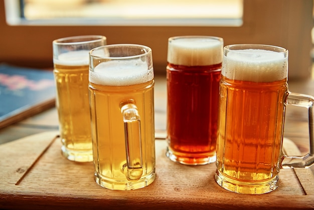 Conjunto de cuatro vasos con diferentes tipos de cerveza en la mesa