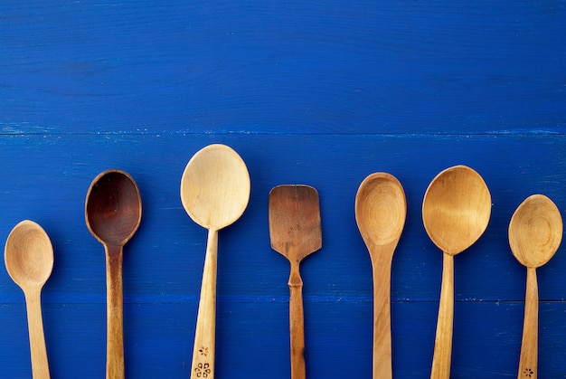 Conjunto de cucharas vintage de madera amarillas sobre un fondo azul de madera