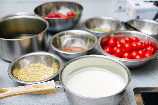 Foto conjunto de cuencos y sartenes de acero inoxidable con productos en bruto