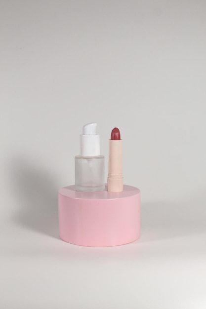 Foto conjunto de cuidado de la piel y cosmética con podio rosa y fondo blanco.