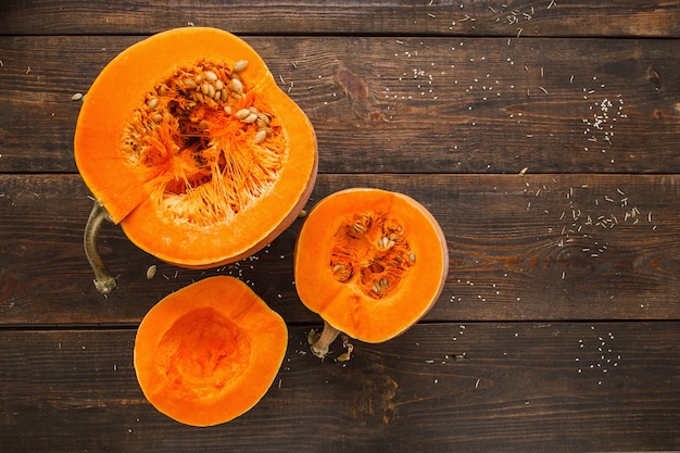 Conjunto de abóboras laranja no espaço plano de madeira leigos. Abóboras recém-cortadas na mesa de madeira, fundo de outono do país