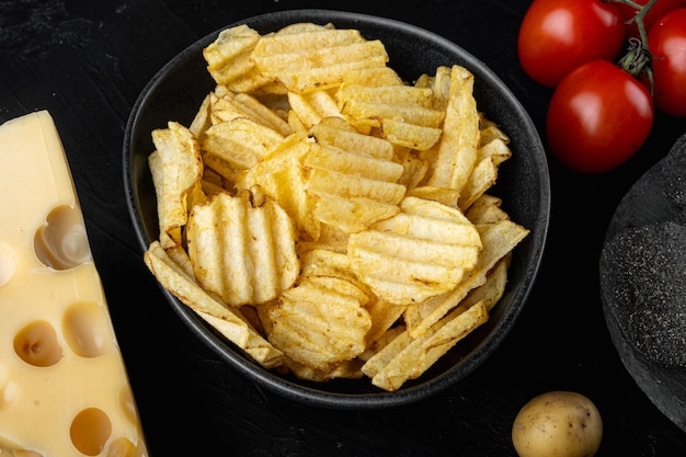 Conjunto de batatas fritas crocantes, em mesa de pedra preta