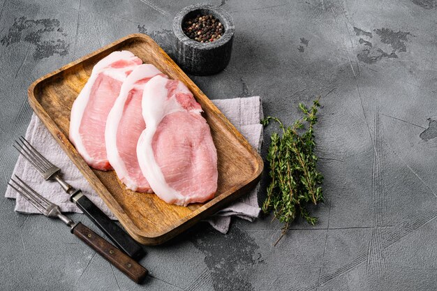 Conjunto de bife de carne crua fresca, no fundo da mesa de pedra cinza, com espaço de cópia para texto