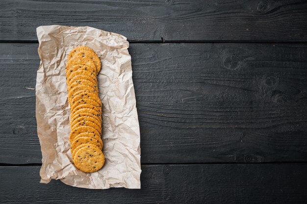 Conjunto de biscoitos de aptidão saudável multigrãos, em fundo preto de madeira, plano com espaço de cópia para o texto