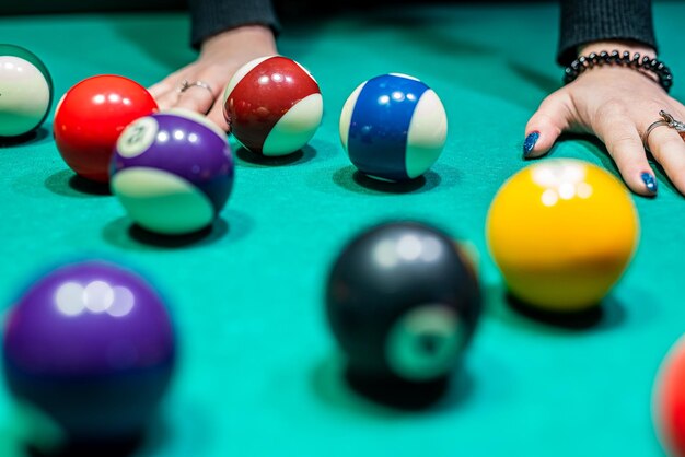 Bolas de bilhar na mesa de bilhar com as mãos e pau do jogador o conceito  de esportes e jogos de azar