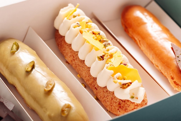 Conjunto de bolos eclair com recheios diferentes em uma caixa fechada Sobremesa francesa tradicional