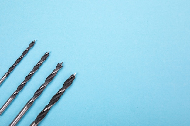 Foto conjunto de brocas estão espalhados em uma linha no fundo azul