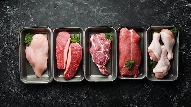 Foto conjunto de carne fresca de vitela de frango de porco em um fundo de pedra preta alimentos orgânicos