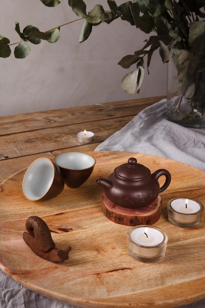 Conjunto de chá asiático tradicional - bule de cerâmica e xícaras de chá para a cerimônia do chá em uma mesa de madeira. Estilo vintage.