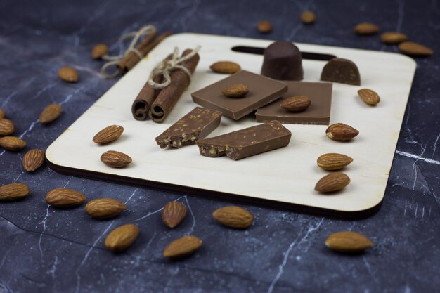 Foto conjunto de chocolate para servir em uma prancha de madeira em uma mesa escura prato doce de barras de chocolate