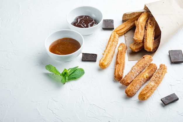 Conjunto de churros saborosos com calda de chocolate e caramelo