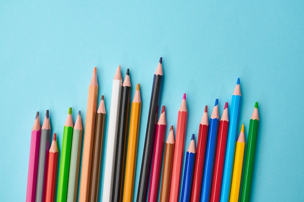 Conjunto de closeup de lápis coloridos, fundo azul. Material de papelaria para escritório, acessórios escolares ou educacionais, ferramentas de escrita e desenho