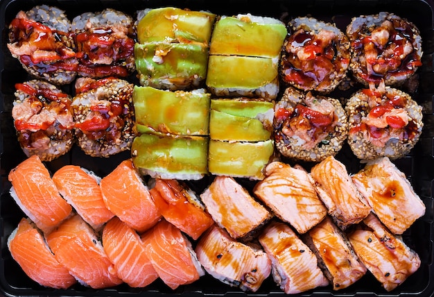 Conjunto de comida asiática. Sushi, rolos em um fundo preto. Vista superior, acima