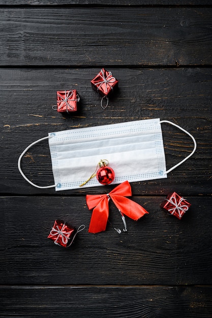 Conjunto de conceitos de Covid durante a temporada de Natal, no fundo preto da mesa de madeira, vista superior plana lay