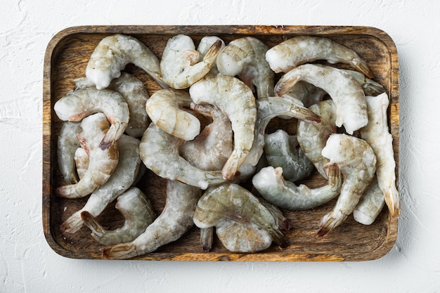 Conjunto de conchas congeladas em camarões tigre ou camarões tigre asiáticos, em bandeja de madeira