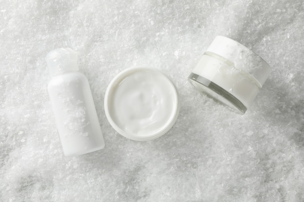 Conjunto de cosméticos, pote de creme de inverno para a pele na neve, espaço para texto. vista do topo