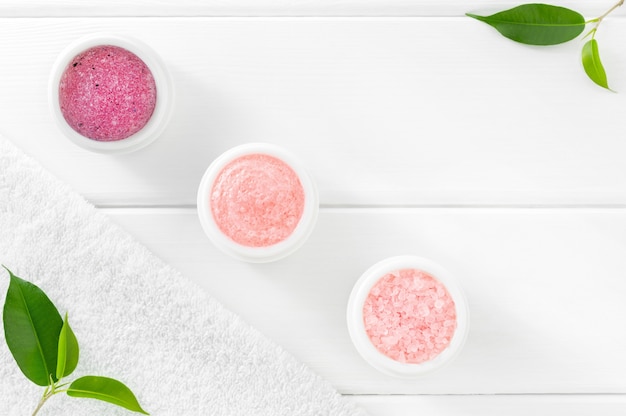 Foto conjunto de cosméticos rosa para cuidados com o corpo em camada plana e branca