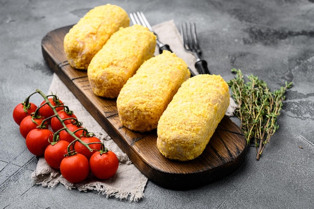 Conjunto de costeletas de frango à milanesa crua, no fundo da mesa de pedra cinza