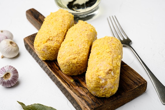 Conjunto de costeletas de frango no pão ralado, no fundo da mesa de pedra branca