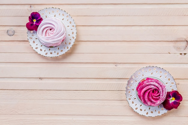 Conjunto de cupcakes caseiros de brancos e rosa na mesa de madeira