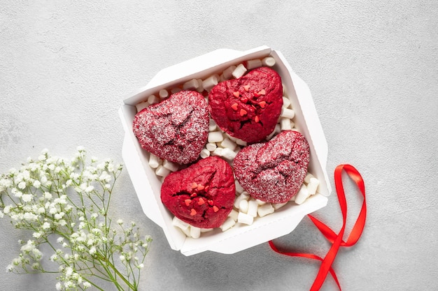 Foto conjunto de cupcakes de veludo vermelho em caixa de papel com flores de marshmallow e fita