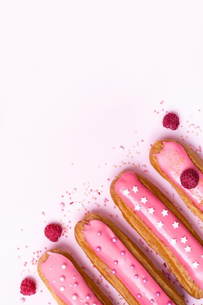 Conjunto de deliciosos doces com esmalte rosa de framboesa sobre fundo branco Decoração de bagas naturais