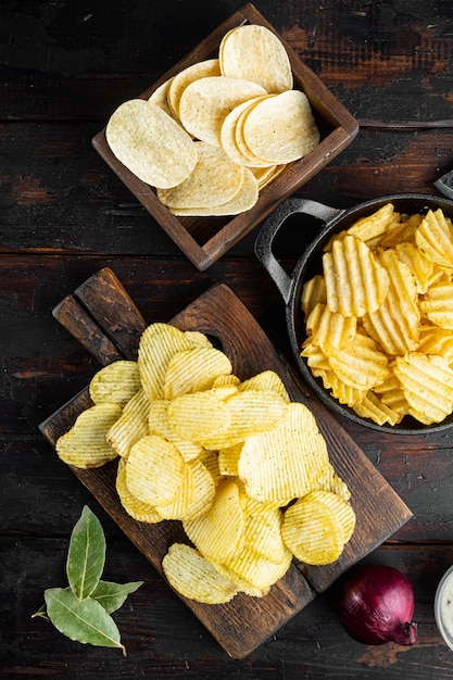 Conjunto de diferentes batatas fritas de variação, na velha mesa de madeira escura