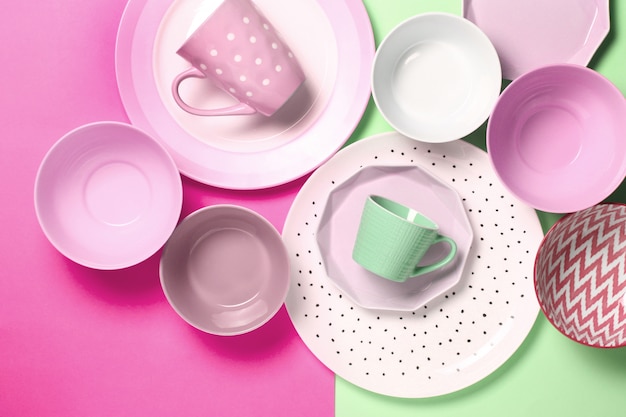Conjunto de diferentes placas brancas e rosa modernas, tigelas e copos em rosa e verde.