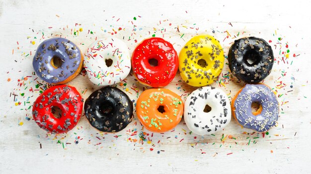 Conjunto de donuts coloridos doces em um fundo branco de madeira Vista superior Flat Lay