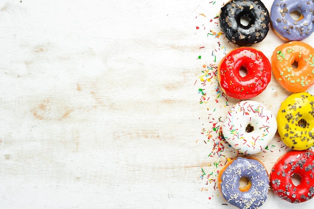 Conjunto de donuts coloridos doces em um fundo branco de madeira Vista superior Flat Lay