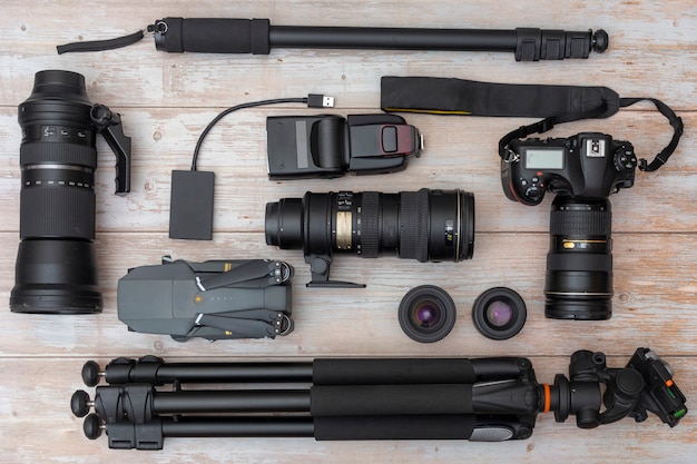 Conjunto de equipamento de câmera e fotografia na mesa de madeira escura. Composição de flatlay para fotógrafo profissional.