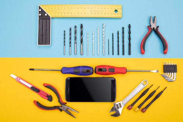 Conjunto de ferramentas de metalurgia com smartphone colorido