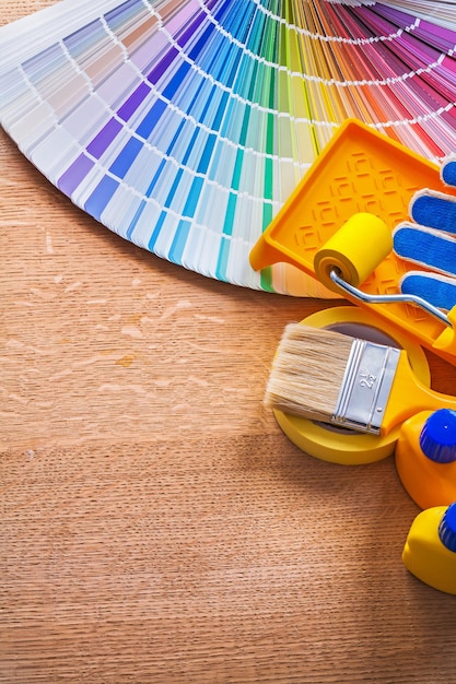 Conjunto de ferramentas de pintura e guia de paleta de cores pantone no conceito de manutenção de placa de madeira