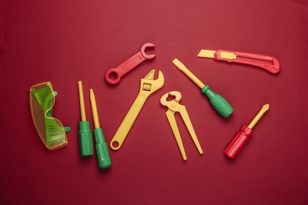 Conjunto de ferramentas de trabalho de brinquedo infantil no vermelho.