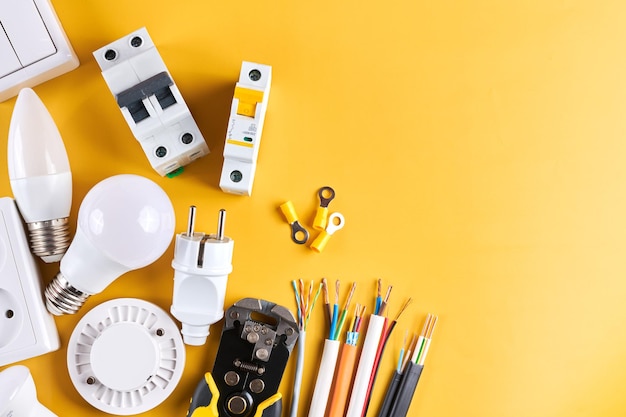 Conjunto de ferramentas elétricas com interruptor dimmer isolado em fundo amarelo com iluminação controlável de espaço de cópia Economizando energia conceito construção e renovação