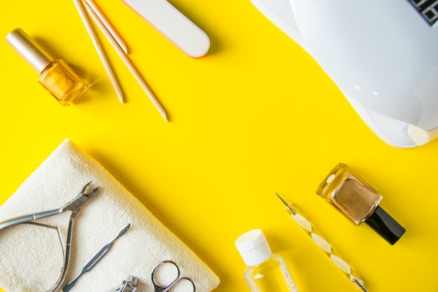 Conjunto de ferramentas para manicure e tratamento de unhas em um fundo amarelo. Lugar para texto.